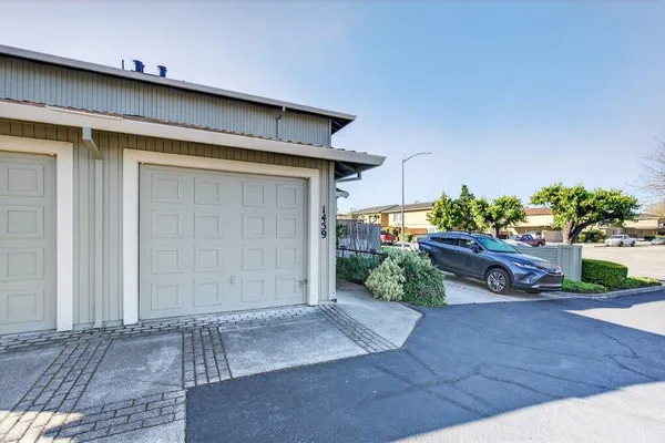 a view of a house with a small yard and floor to ceiling window