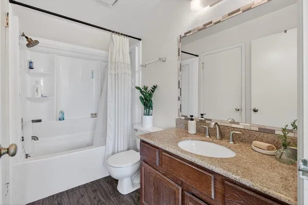 a bathroom with a granite countertop sink a toilet and a mirror