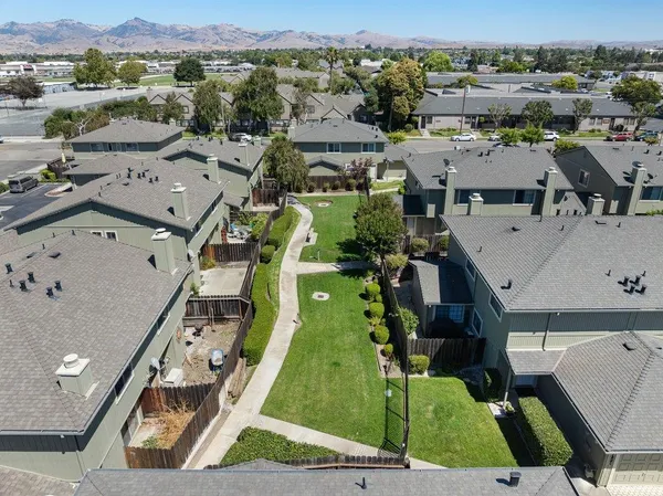 an aerial view of residential houses with outdoor space and parking