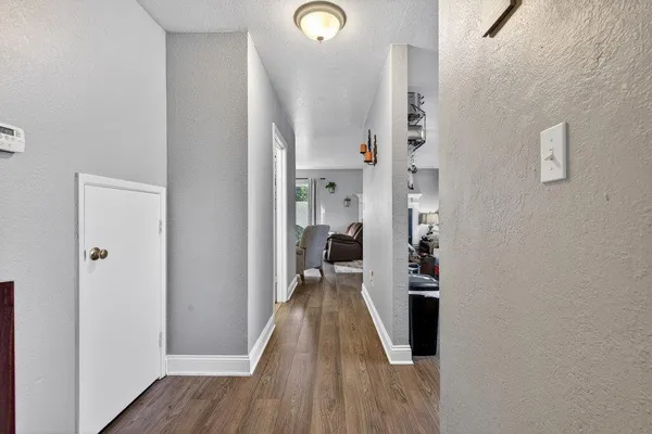 a view of entryway and hall with wooden floor