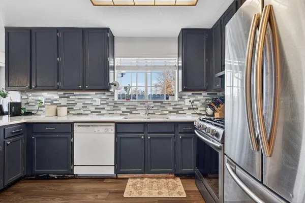 a kitchen with kitchen island granite countertop a sink cabinets and wooden floor