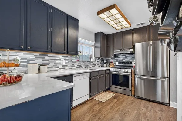a kitchen with appliances a sink and cabinets