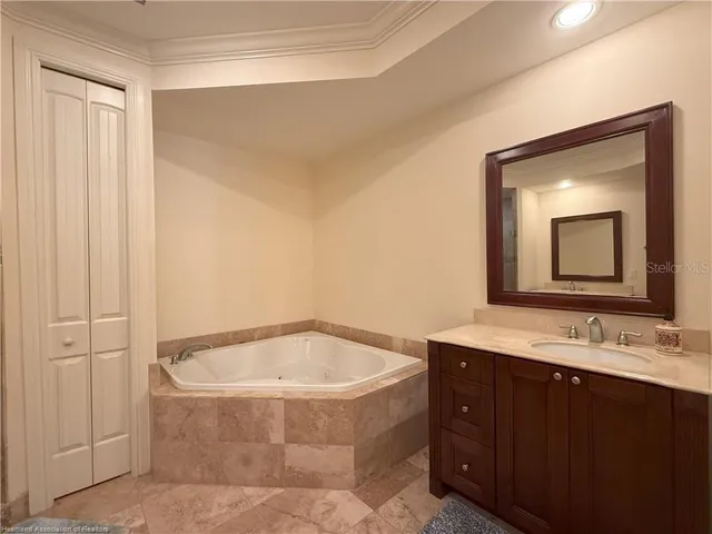 a bathroom with a bathtub a mirror a sink and vanity