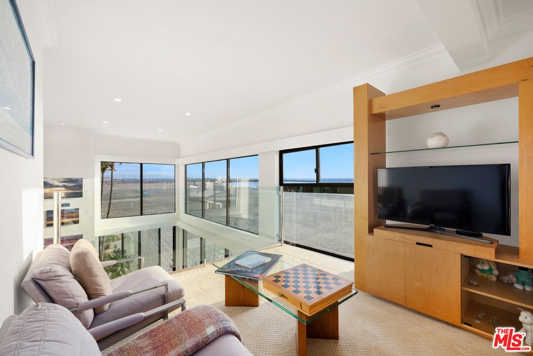 1 Northstar Street, Unit PH1 Marina del Rey, CA 90292 - Photo 10 of 18 a living room with furniture a flat screen tv and a floor to ceiling window