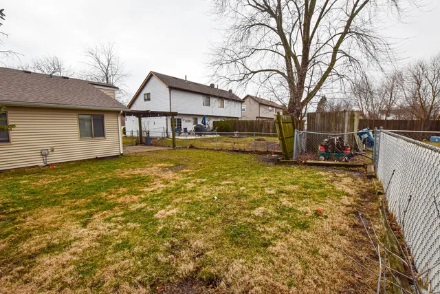a view of a house with a large tree and a yard