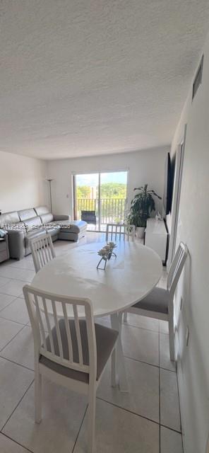 4801 Northwest 7th, Unit 40216 Miami, FL 33126 - Photo 4 of 14 a kitchen with a table chairs and a refrigerator