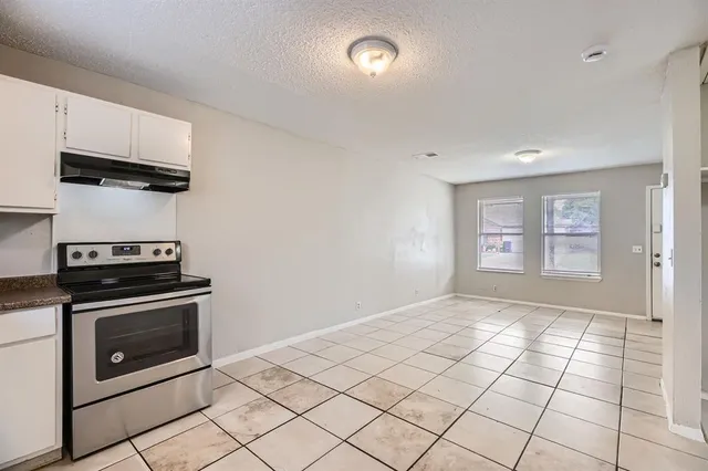 a view of a kitchen with a stove top oven and cabinets