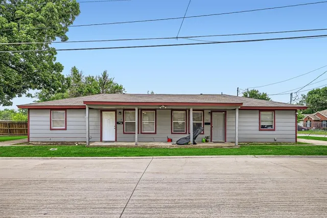 a front view of a house with a garden and trees