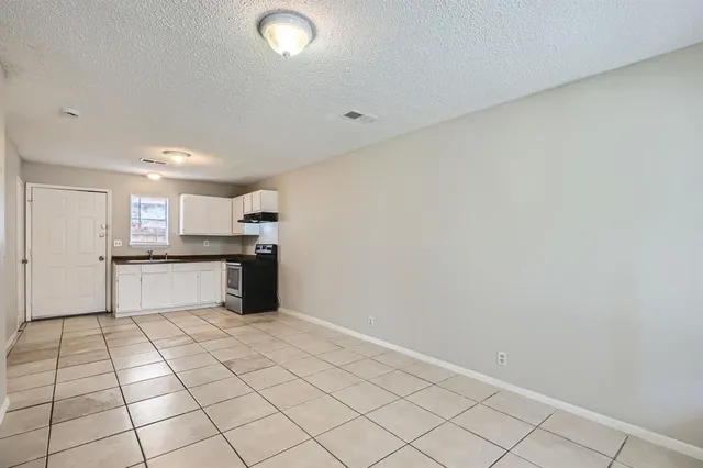 a large white kitchen with a sink and cabinets