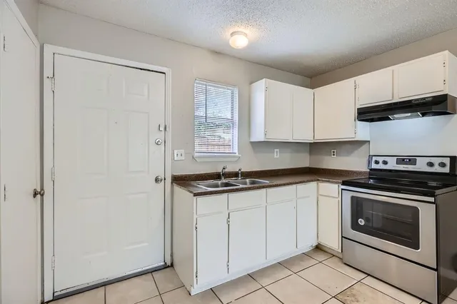 a kitchen with granite countertop white cabinets and white appliances