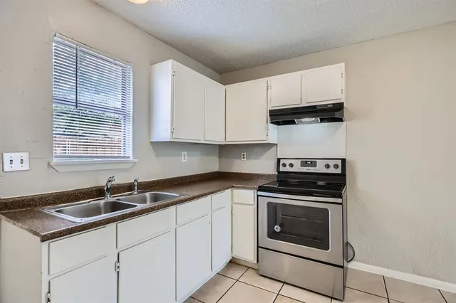 a kitchen with white cabinets sink and stainless steel appliances