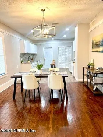 a view of a dining room with furniture wooden floor and chandelier