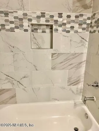 a bathroom with a bathtub and shower