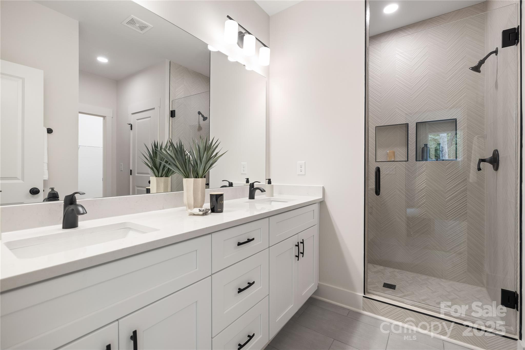 8937 Penstemons Drive Charlotte, NC 28215 - Photo 17 of 31 a bathroom with a double vanity sink mirror and shower
