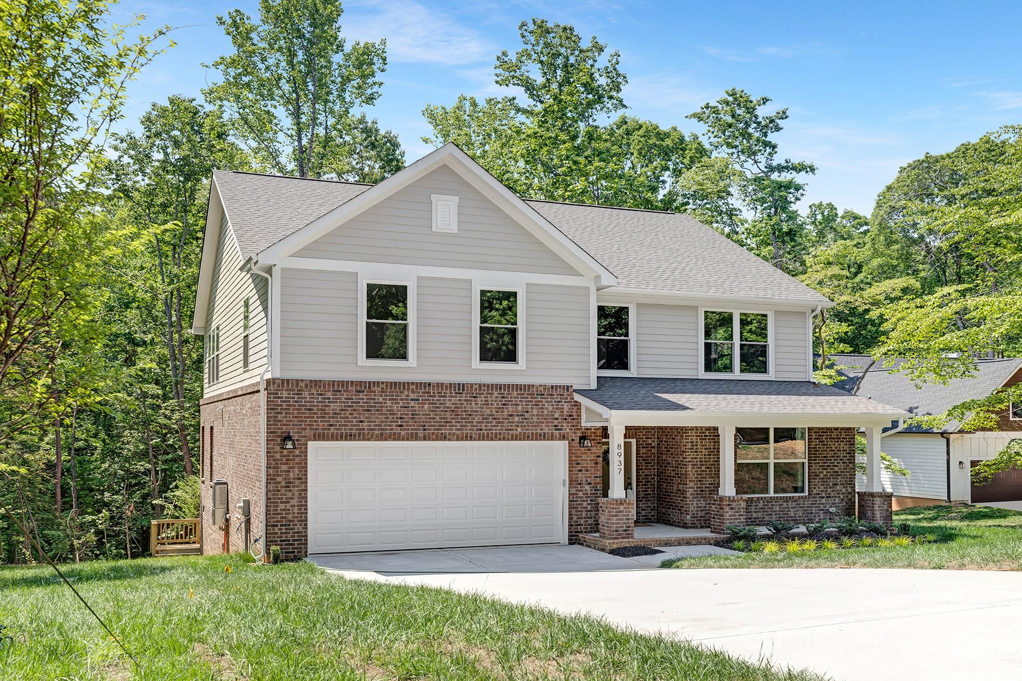 8937 Penstemons Drive Charlotte, NC 28215 - Photo 2 of 31 a front view of a house with a yard and garage