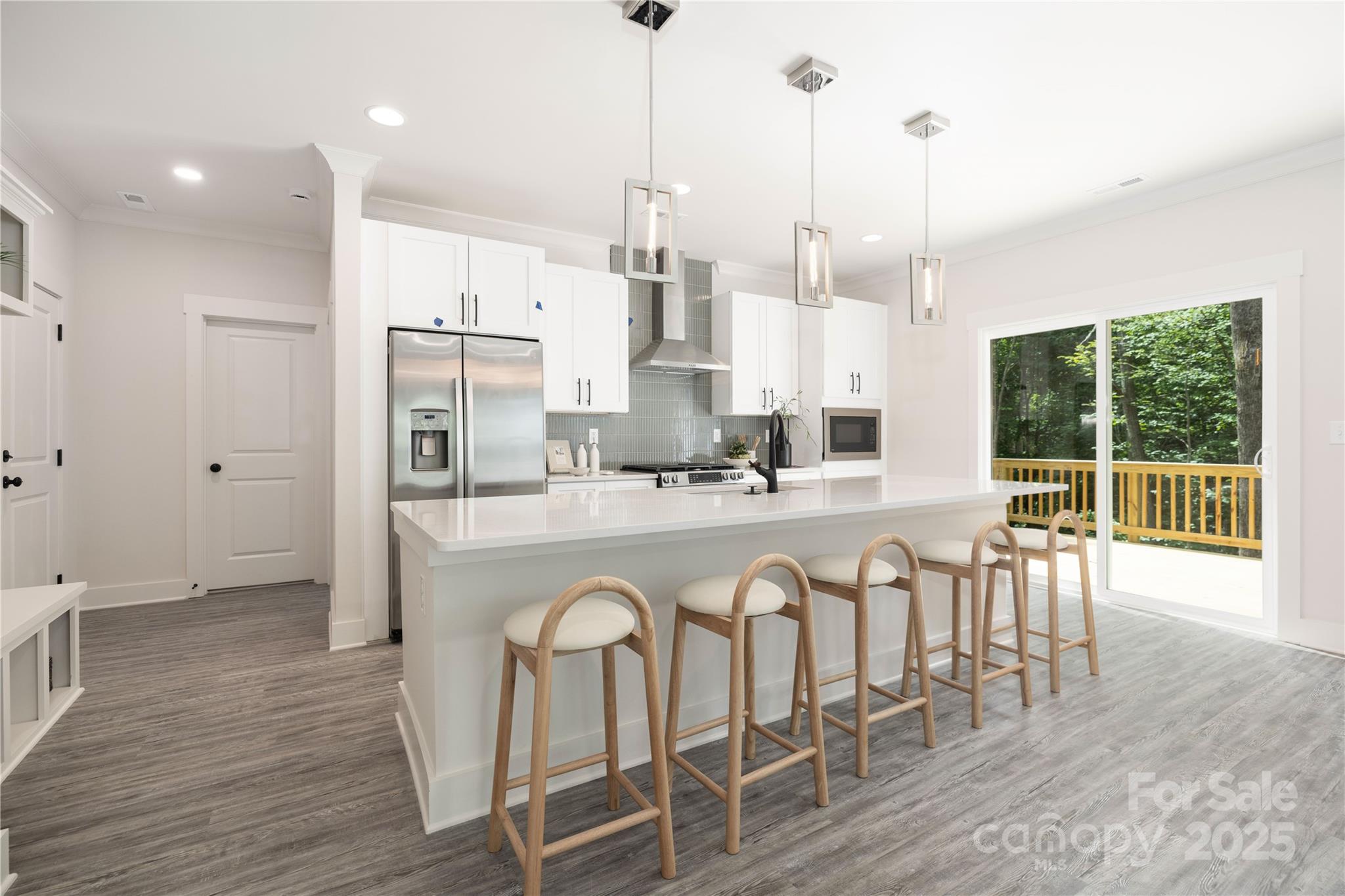 8937 Penstemons Drive Charlotte, NC 28215 - Photo 10 of 31 a large white kitchen with granite countertop a stove a sink with island and chairs