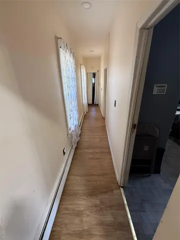 a view of a hallway with wooden floor and stairs