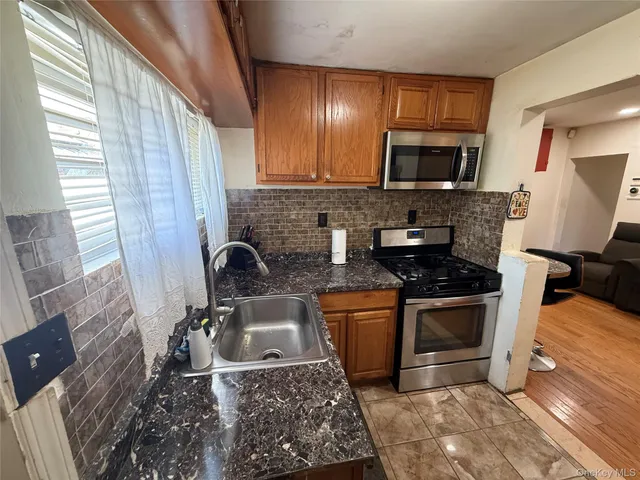 a kitchen with stainless steel appliances granite countertop a stove a sink and a microwave