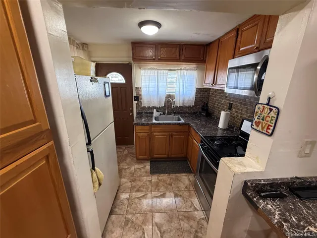 a kitchen with sink a refrigerator and cabinets