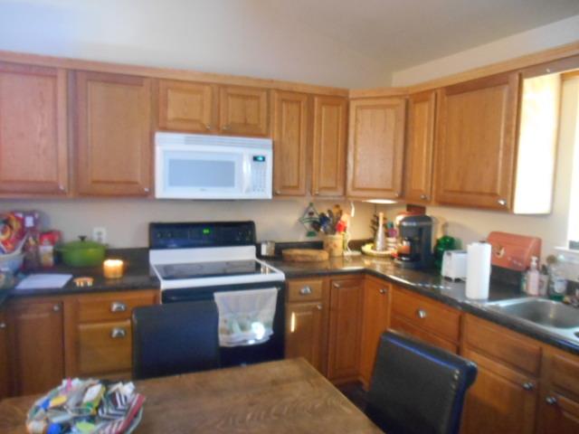 1207 Loving Street Mason, TX 76856 - Photo 4 of 10 a kitchen with granite countertop a sink stove and cabinets