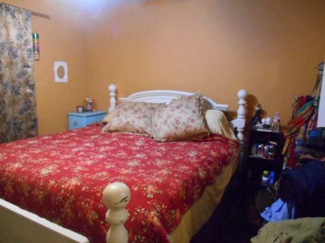 1207 Loving Street Mason, TX 76856 - Photo 5 of 10 a bedroom with a bed and a chandelier