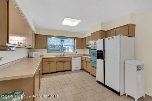a kitchen with a white refrigerator cabinets a sink and a stove