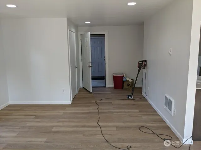 an empty room with wooden floor and windows