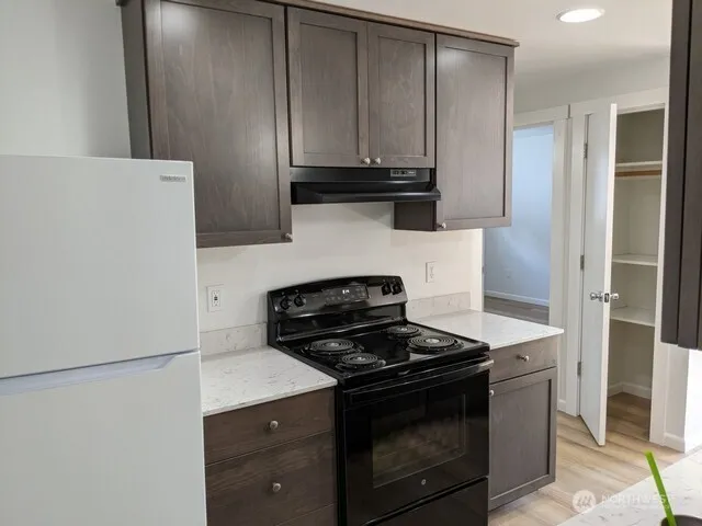 a kitchen with granite countertop a stove and a refrigerator