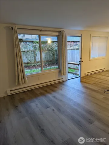 a room with wooden floor a chandelier and windows