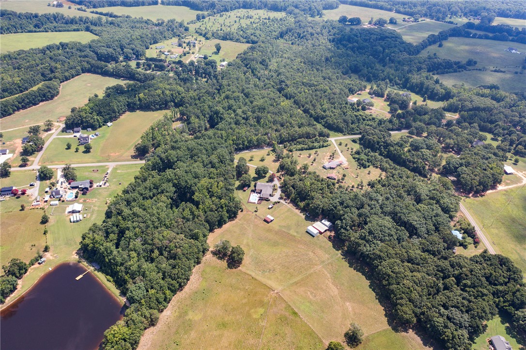 911 State Rd S-4-203 Belton, SC 29627 - Photo 49 of 49 An aerial panorama reveals verdant woodlands, open fields, and residential properties interspersed with serene waters.