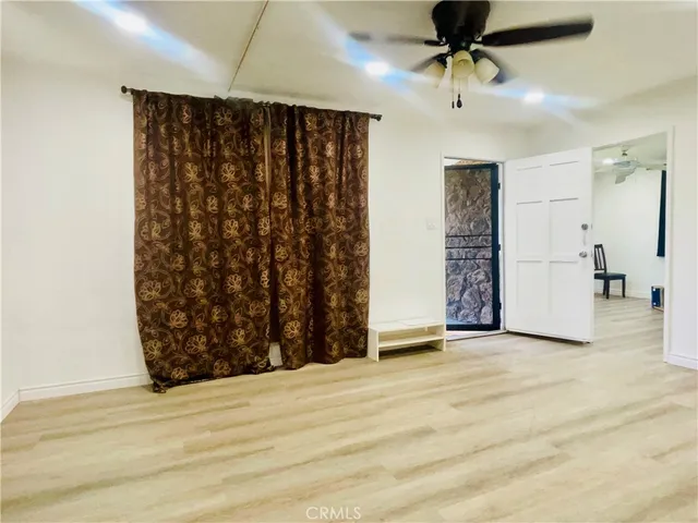 a view of an empty room with a ceiling fan