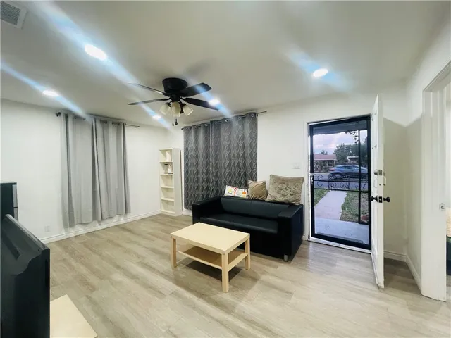 a living room with furniture and a ceiling fan