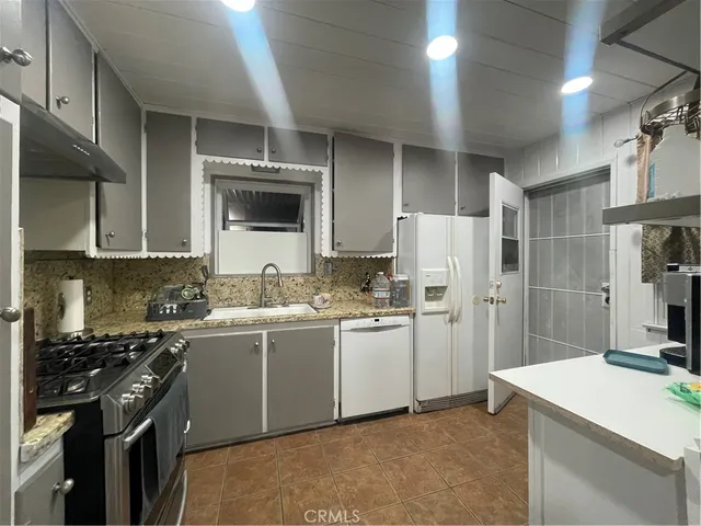 a kitchen with stainless steel appliances granite countertop a refrigerator stove and sink