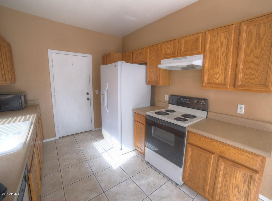 3902 West Carter Road Phoenix, AZ 85041 - Photo 15 of 38 a kitchen with a stove top oven and cabinets