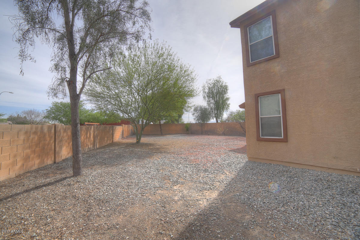 3902 West Carter Road Phoenix, AZ 85041 - Photo 20 of 38 a view of a backyard with large trees and wooden fence