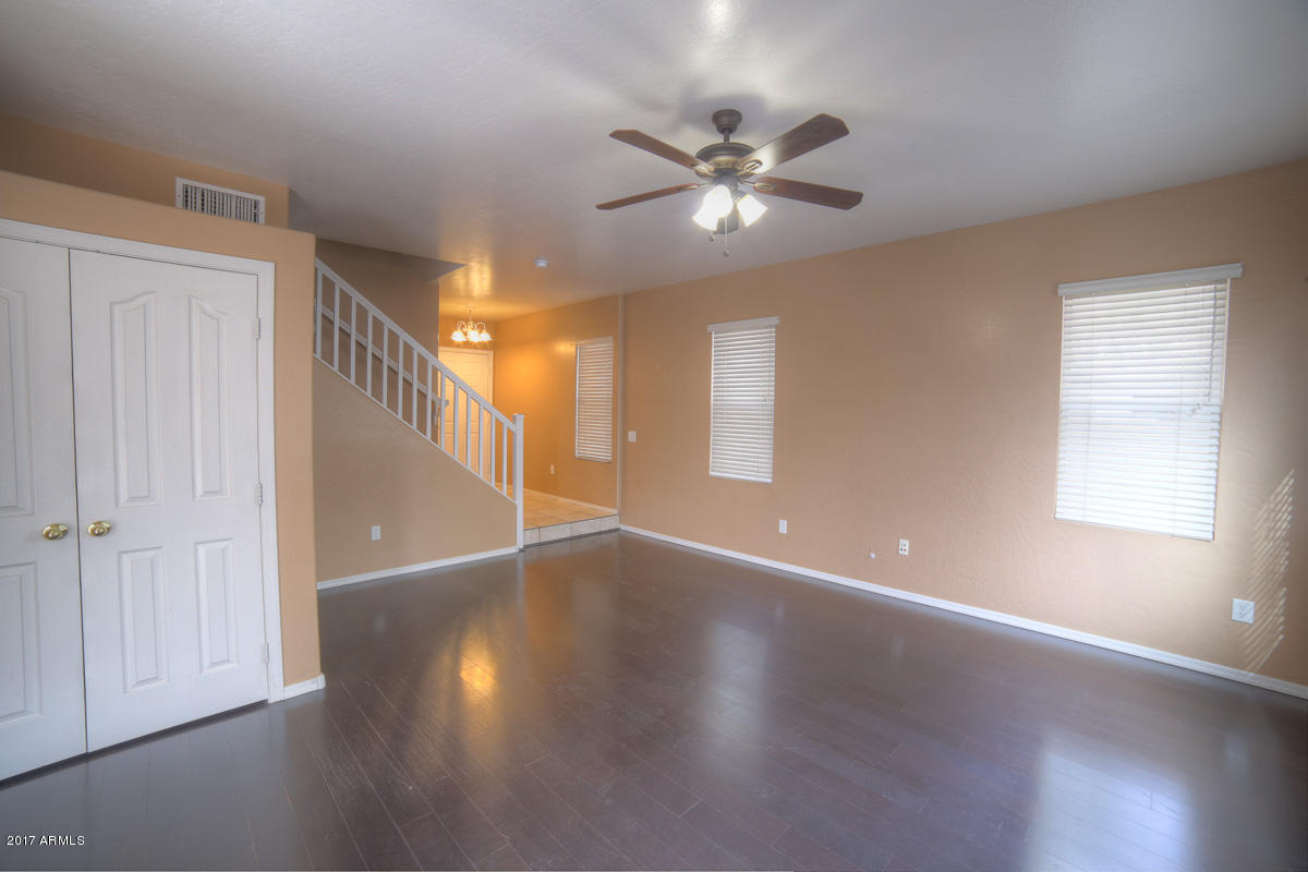 3902 West Carter Road Phoenix, AZ 85041 - Photo 8 of 38 a view of an empty room with wooden floor and window