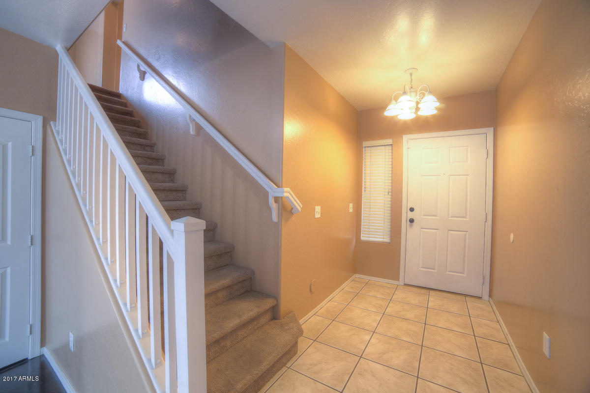3902 West Carter Road Phoenix, AZ 85041 - Photo 10 of 38 a view of a hallway with wooden floor and staircase