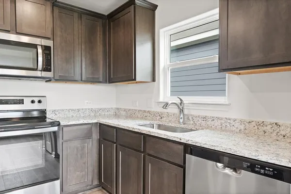 a kitchen with granite countertop cabinets stainless steel appliances and a sink