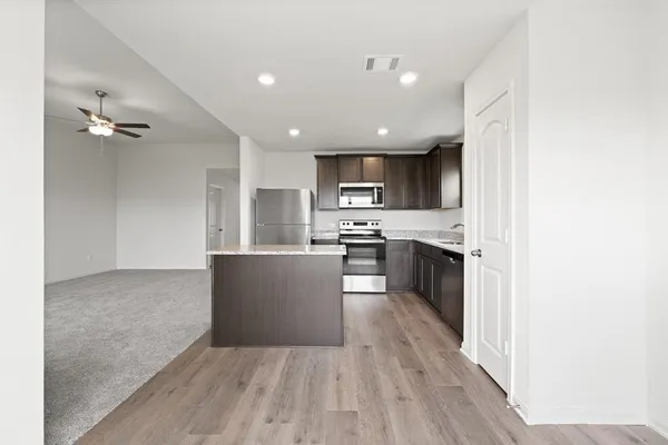 a kitchen with a sink a counter top space stainless steel appliances and cabinets