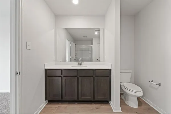 a bathroom with a granite countertop toilet a sink and a mirror
