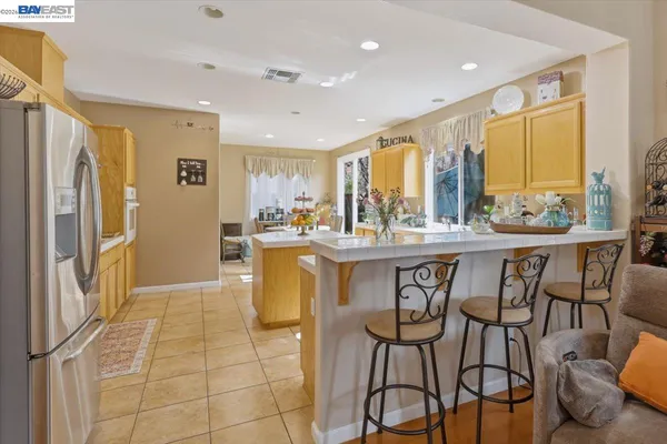a dining hall with stainless steel appliances a dining table and chairs