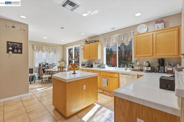a kitchen with sink a counter top space and living room view