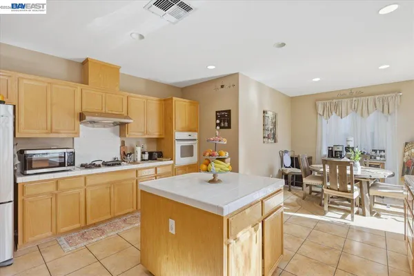 a kitchen with stainless steel appliances granite countertop a sink and a refrigerator