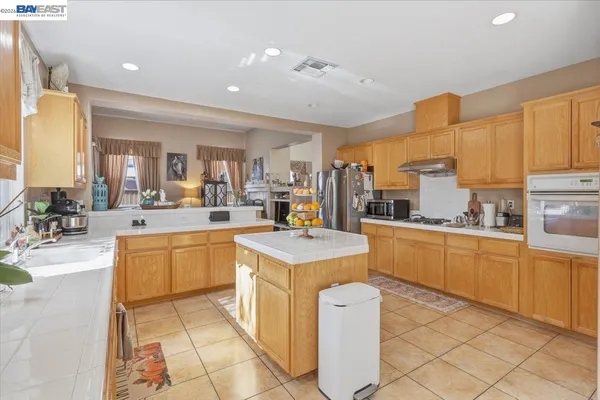 a kitchen with sink a counter top space and living room view