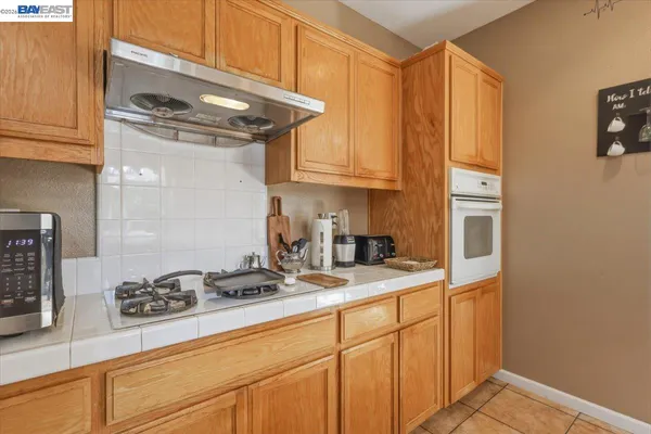a kitchen with a sink a refrigerator and chairs