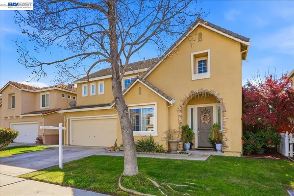 a front view of a house with a yard and trees