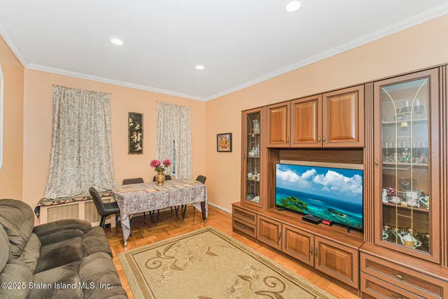 a living room with furniture a flat screen tv and a floor to ceiling window
