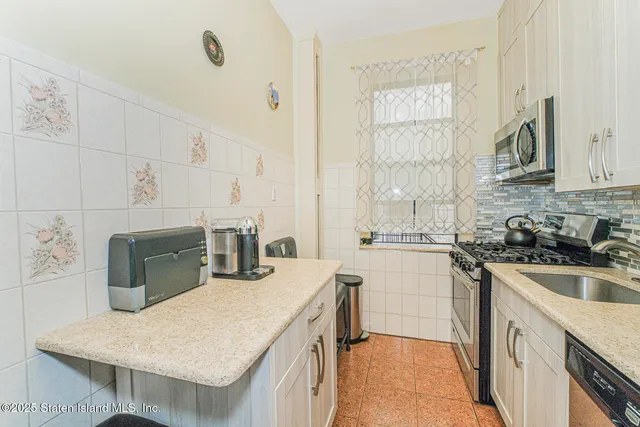 a kitchen with kitchen island a sink stove top oven and microwave