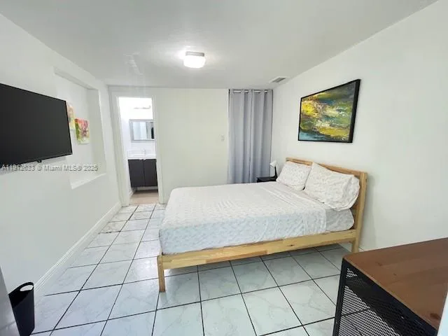 a bedroom with a bed and a flat screen tv