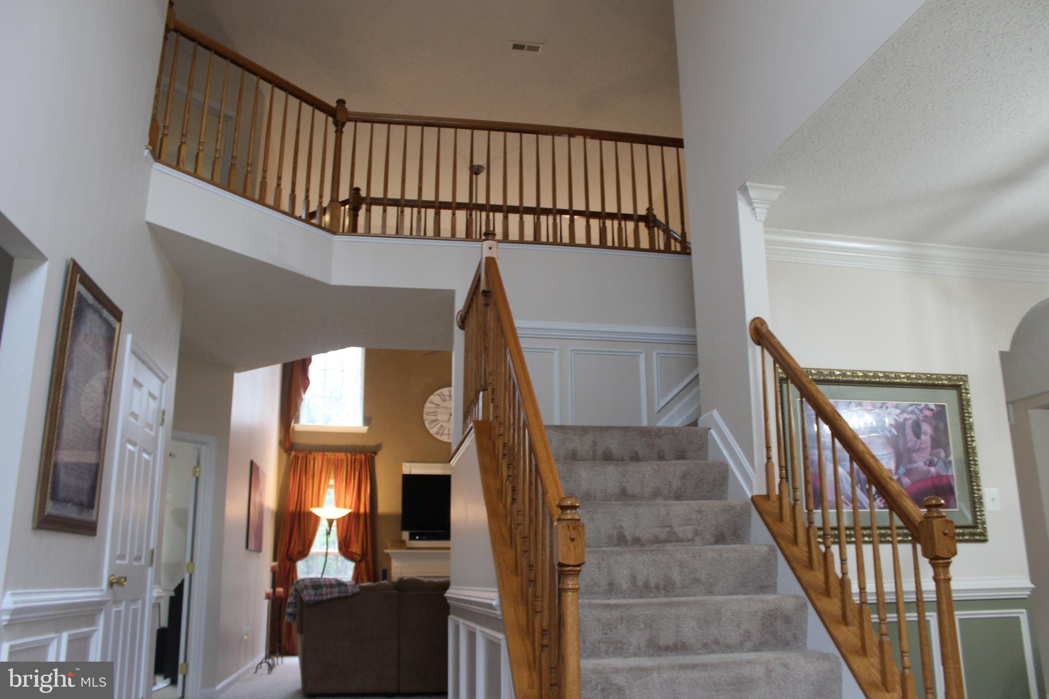 3470 Malcolm Road Brandywine, MD 20613 - Photo 5 of 55 a view of staircase with wooden floor and a chandelier